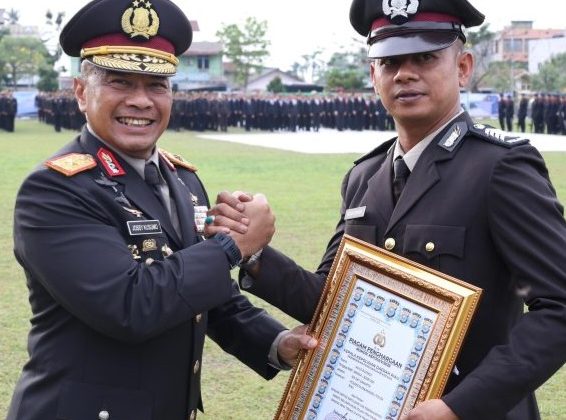 Wakapolda Riau, Brigjen Pol Jossy Kusumo, SH, M.Han., menyerahkan penghargaan kepasa Bripka Agus.
