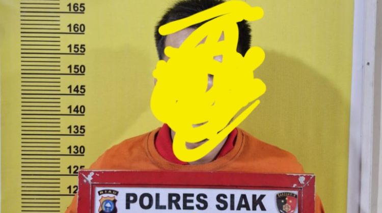 Tersangka Ibr saat diamankan di Mapolres Siak.