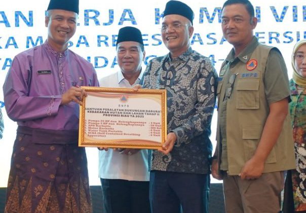 Pj Sekdaprov Riau M. Job Kurniawan saat menerima berbagai bantuan.