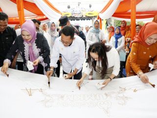 Wali Kota Batam, Amsakar Achmad, Wakil Wali Kota Batam, Li Claudia Chandra, Ketua TP-PKK Kota Batam, Erlita Amsakar, membatik di atas kain putih. F: Ist

