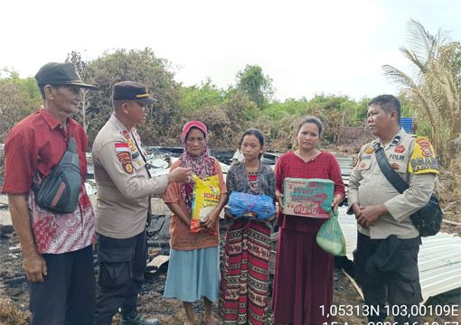 Foto Wakapolsek Rangsang, Ipda Dongan M. Manalu, bersama Bhabinkamtibmas Desa Tanjung Kedabu, Aipda Daniel User menyerahkan Sembako kepada Korban 