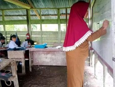  Guru sedang mengajar di ruang kelas bocor saat hujan turun. (Foto: ist)