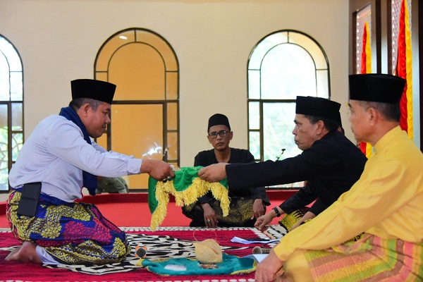 Penyerahan perlengkapan adat untuk pemotongan kerbau kenduri