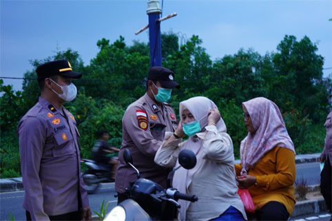 Personel kepolisian bagikan masker kepada masyarakat. (Foto: ist)