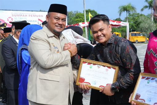 Wakil Bupati Siak Syamsurizal menyerahkan penghargaan kepada Alfo Rahmatul Ikhfar. (Foto: ist)